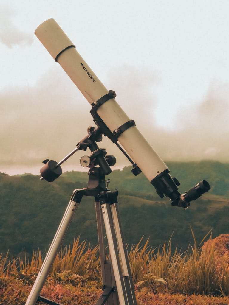A telescope on a tripod set against a lush mountain backdrop under cloudy skies in Cebu.