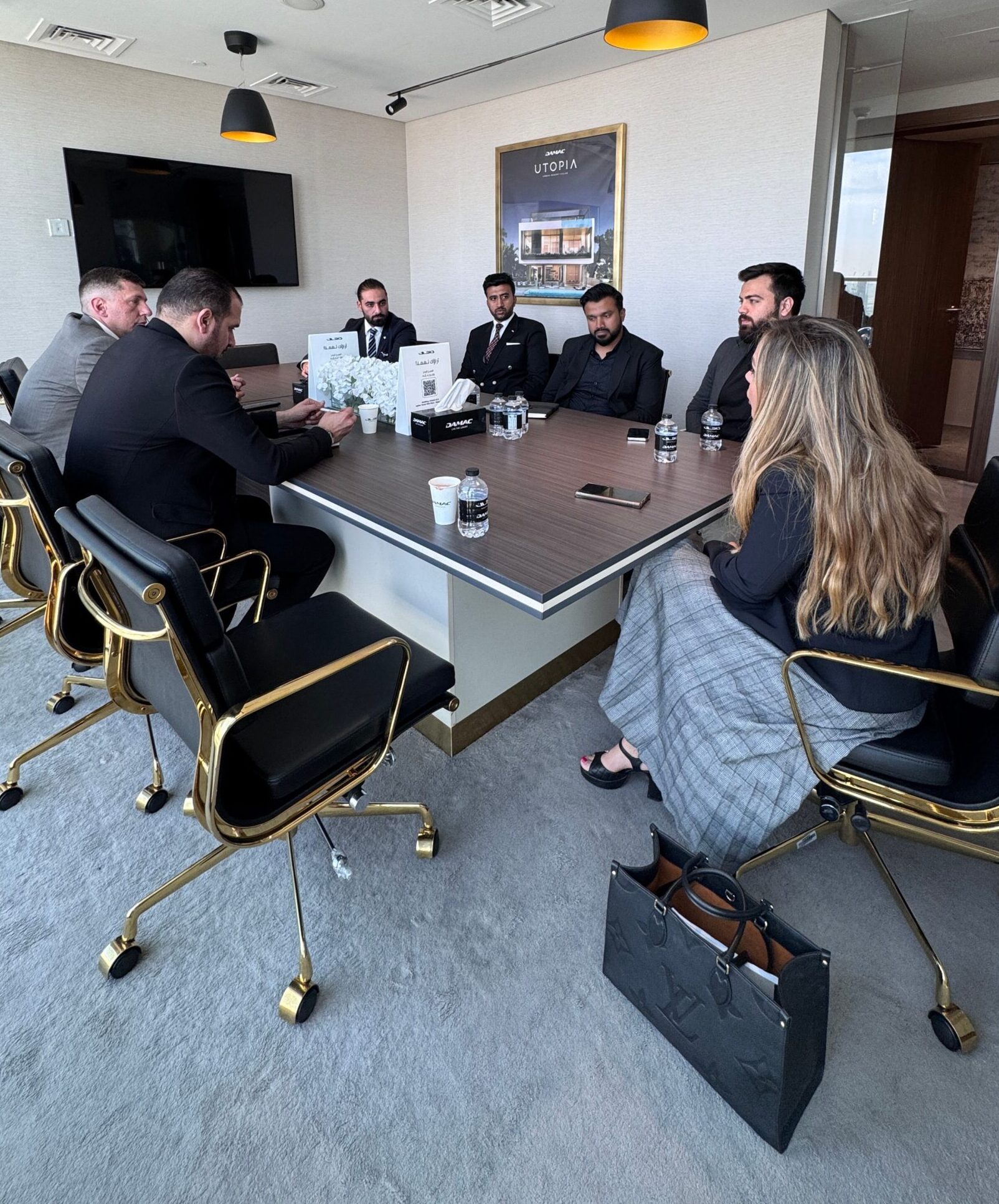 Corporate executives engaged in a meeting in a stylish conference room with modern decor.
